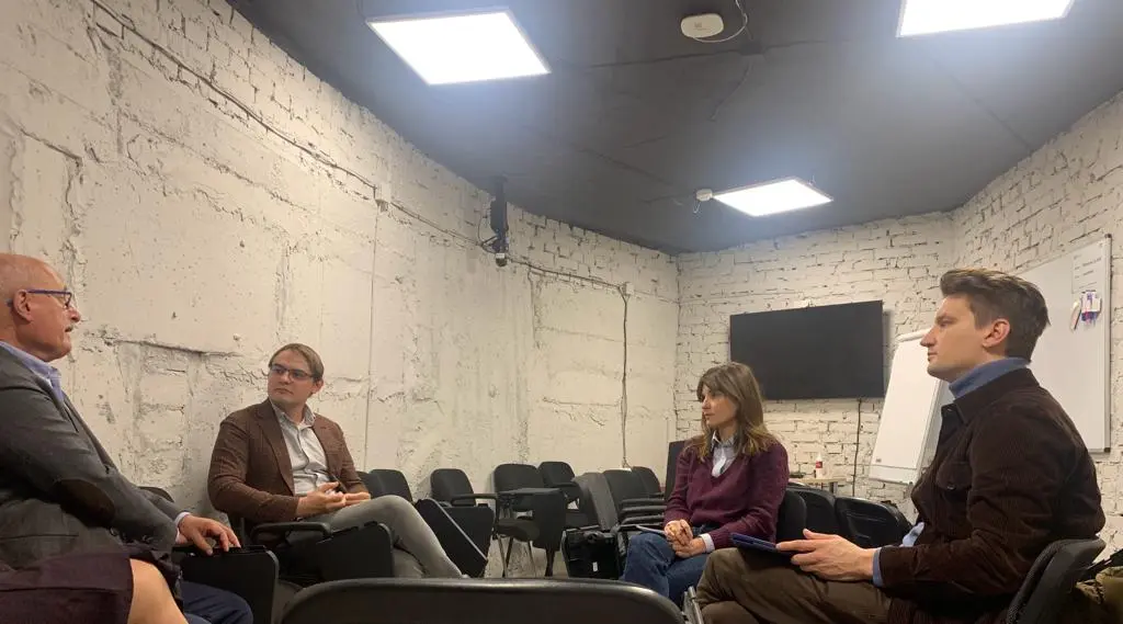 four people sitting, deep in discussion