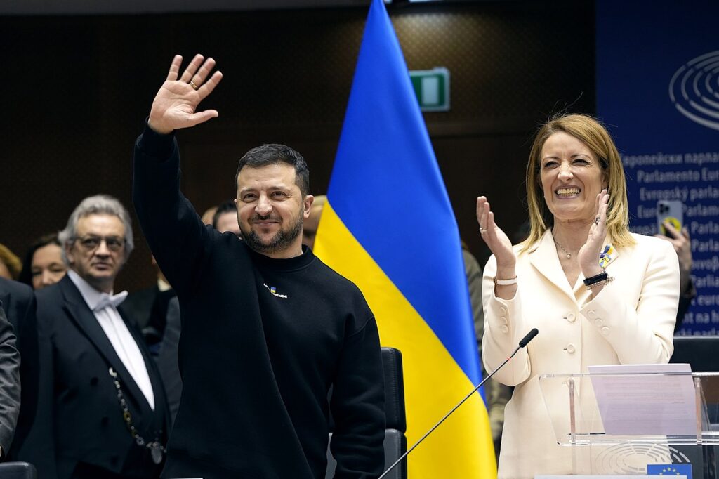 Volodymyr Zelensky waving, European Parliament President Roberta Metsola clapping in the European Parliament in 2022