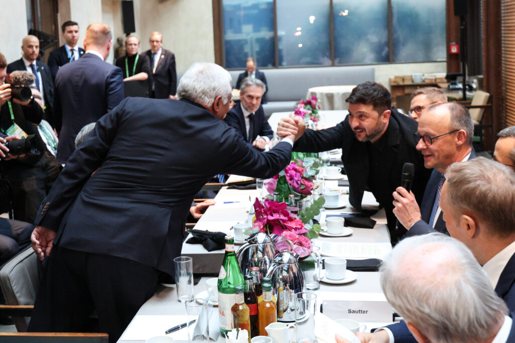 Munich Security Conference 2026, António COSTA (President of the European Council), Volodymyr ZELENSKYY (President of Ukraine) shake hands over a table surrounded by leaders of EU member states, on Feb 13, 2026