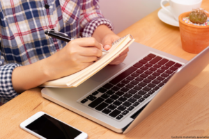 illustration - a person's hands writing in a notebook by a laptop