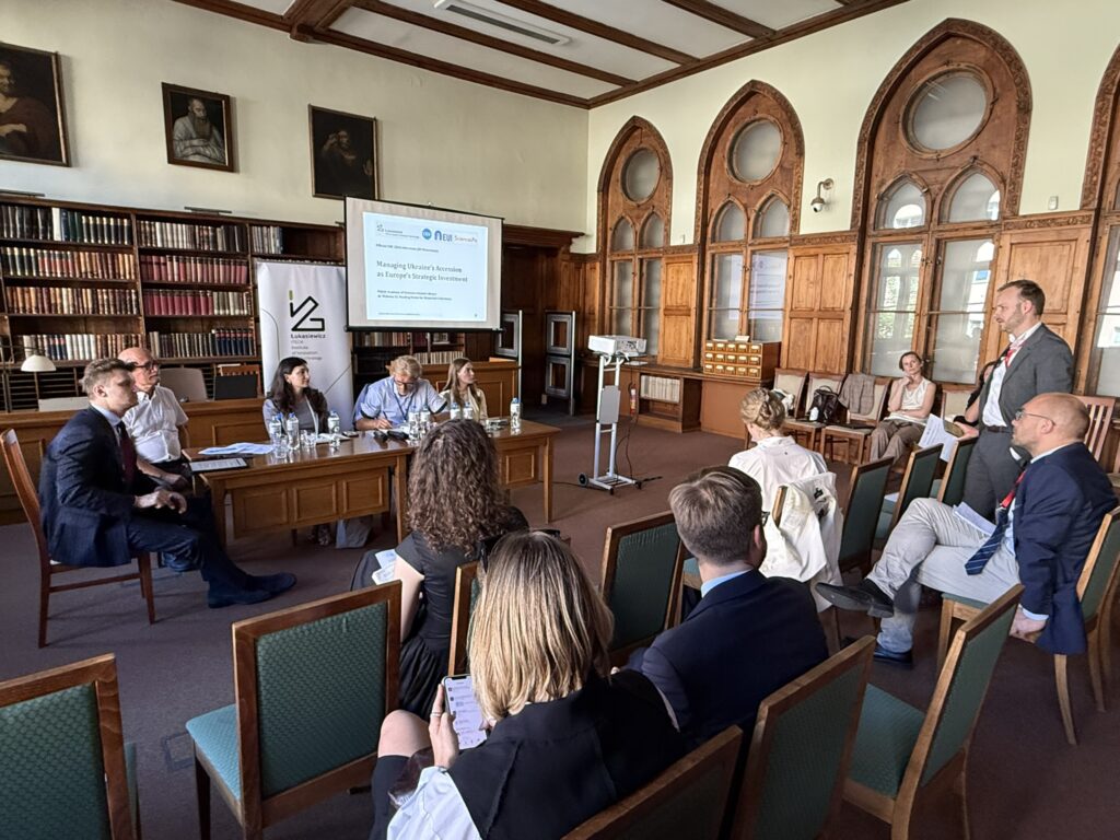 people in a nice room, some around a table, some in the audience