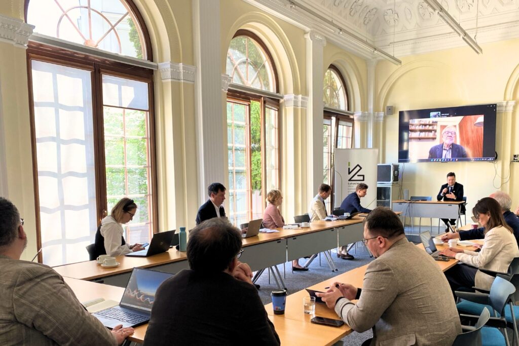 people sitting by desks organized in an oval shape for discussion